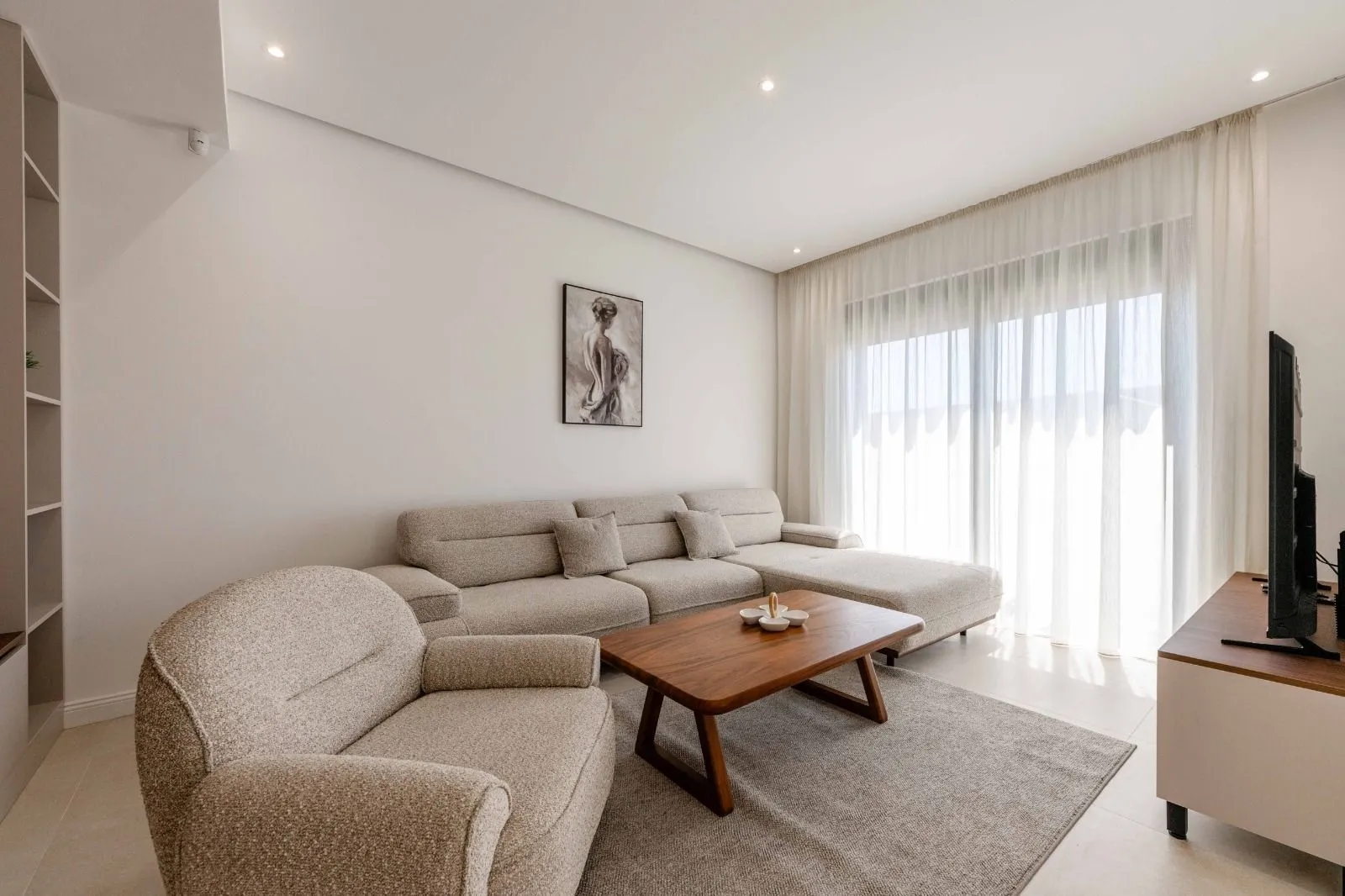 Living room with a sectional sofa, armchair, and wooden coffee table.