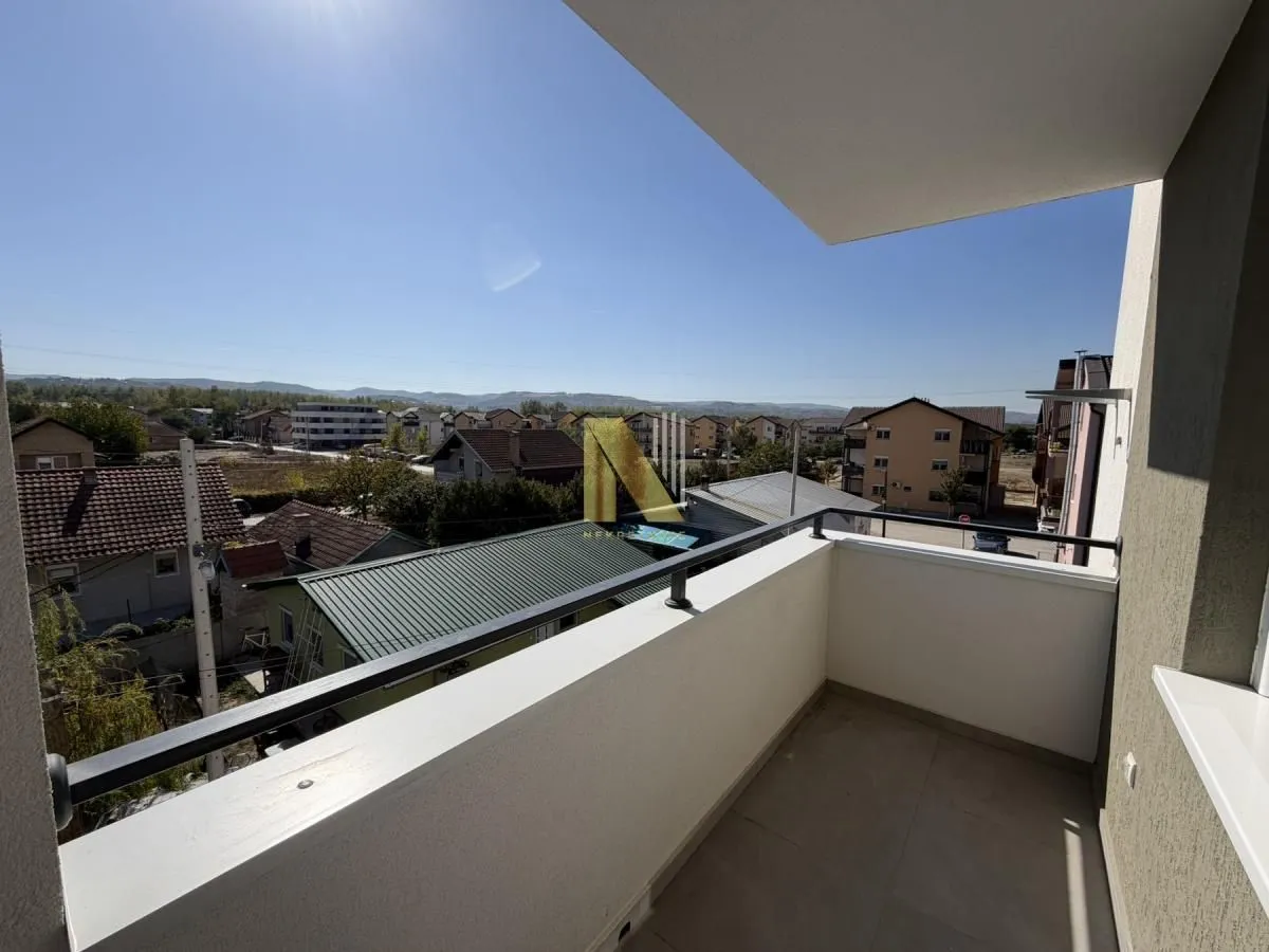 Smaller covered balcony with a metal railing and a view of the neighborhood.