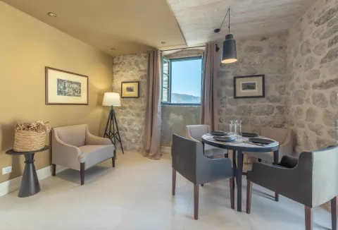 Living room with a dining area and a stone wall. - image 5