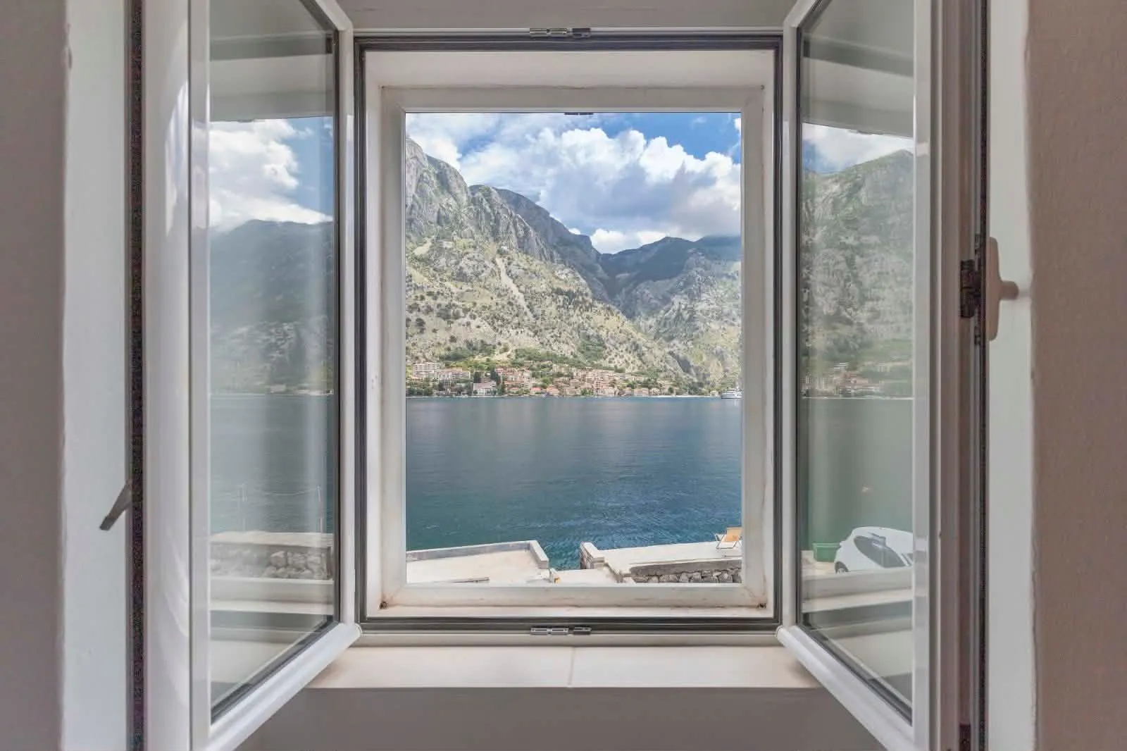 View of the sea and mountains through an open window.