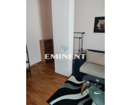 A small section of the living room with a sofa, a glass coffee table, and wooden flooring. - image 9