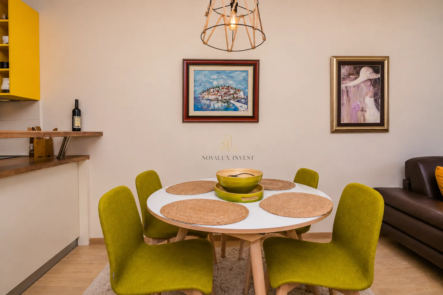 Dining area with a round table and green chairs.