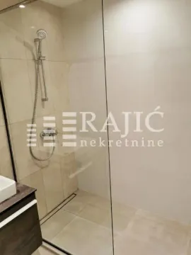 Modernly equipped bathroom with a walk-in shower and vanity. - image 6