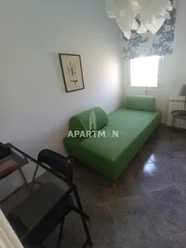 Manja spavaća soba sa zelenim krevetom i radnim stolom. - image 3