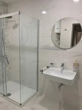 Modernly equipped bathroom with a shower cabin and a sink. - image 8