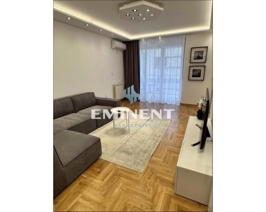 Living room with a sectional sofa, hardwood flooring, and access to the terrace.