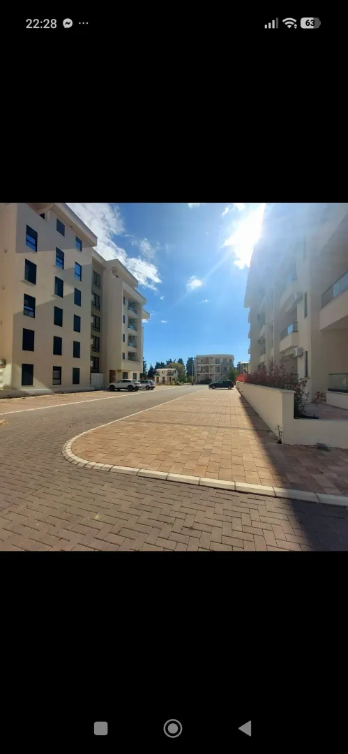 Pogled na dvorište i fasadu stambene zgrade.