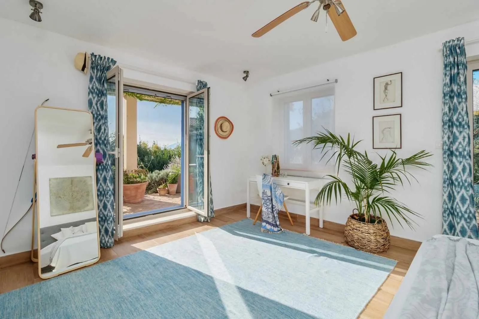 Bright bedroom with access to the terrace and blue details.