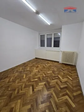 Empty room with hardwood parquet flooring and a radiator. - image 6