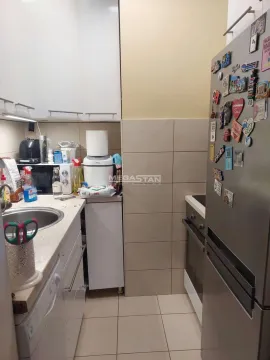 Small kitchen with white cabinets, sink, and refrigerator. - image 14