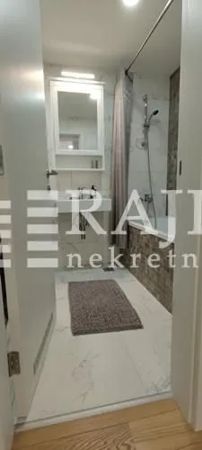 A view of a modern bathroom with a bathtub and a sink.