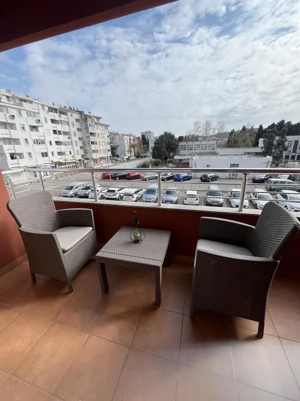 Furnished balcony with seating set and city view.