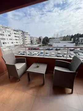 Furnished balcony with seating set and city view. - image 11