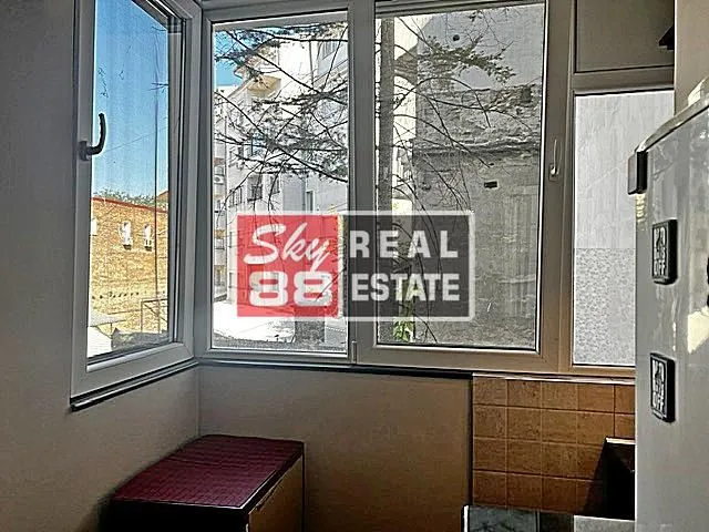 Small kitchen with windows and a view of surrounding buildings.