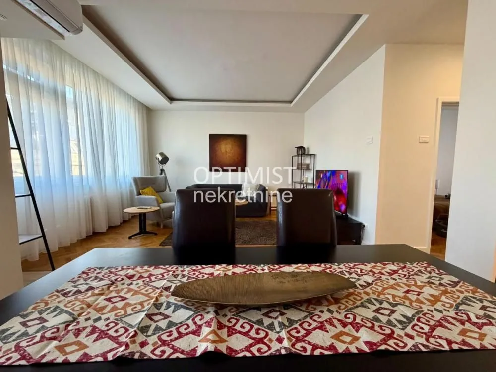 View from the dining area towards the living room with seating and television.
