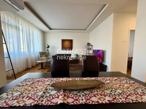 View from the dining area towards the living room with seating and television. - image 12