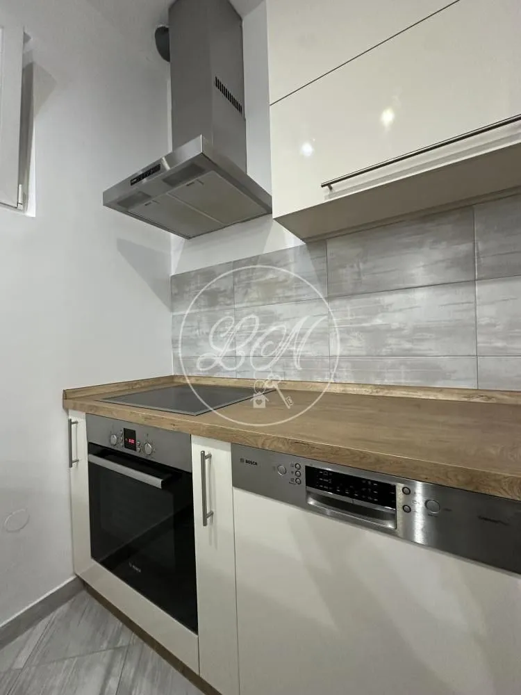 View of a part of the equipped kitchen with built-in appliances and kitchen cabinets.