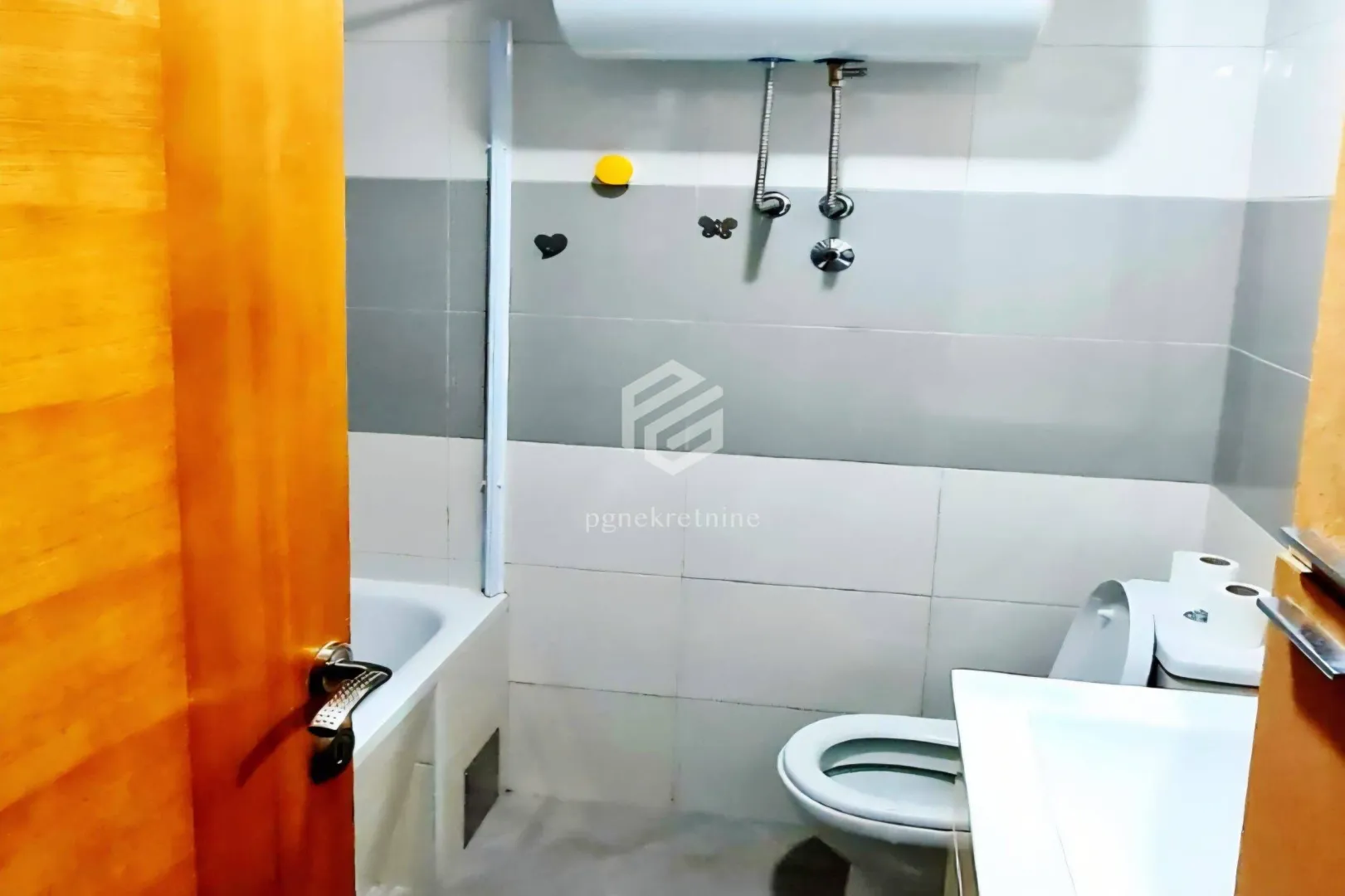 View of the bathroom with a bathtub, toilet, and washbasin.