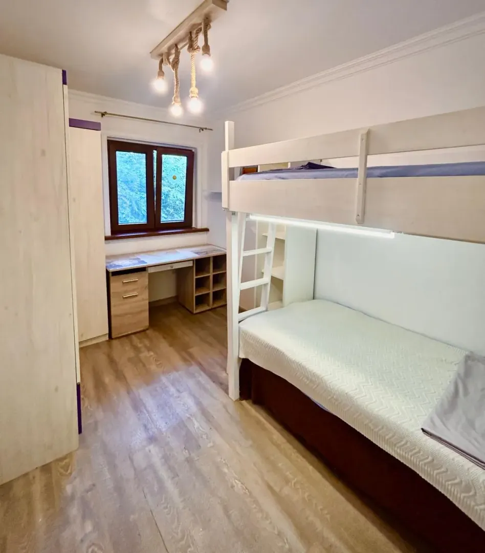 Dječija soba sa krevetom na sprat i radnim stolom.