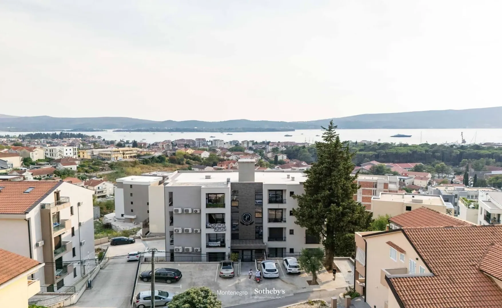 Pogled iz vazduha na spoljašnjost stambene zgrade i okolinu.