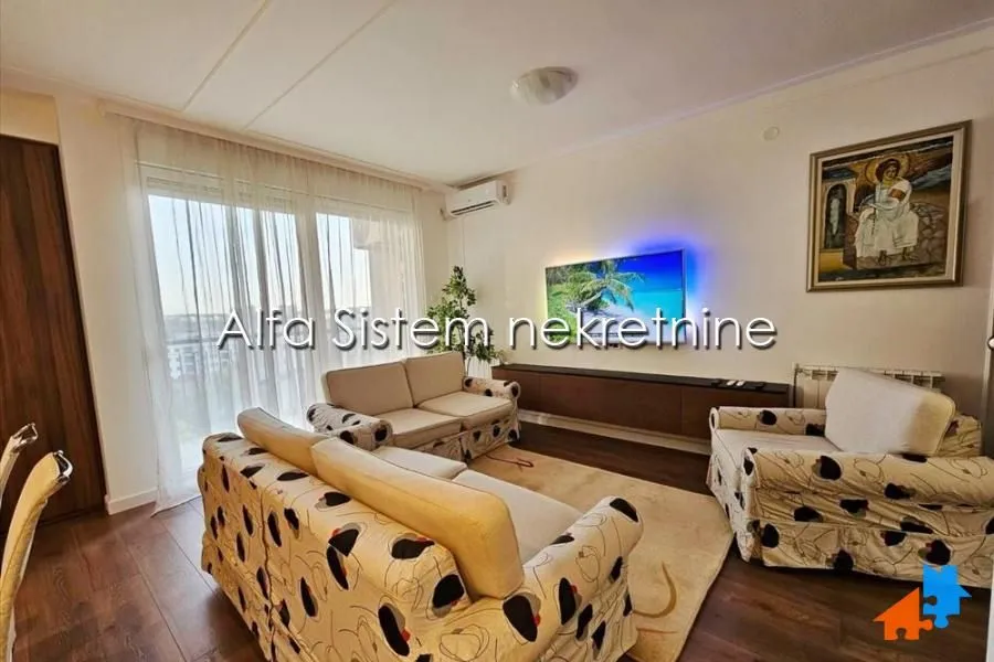 Living room with seating furniture, television, and access to the terrace.
