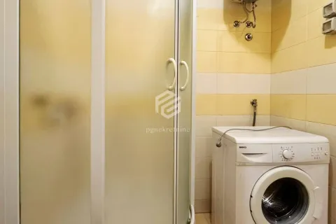 Bathroom with a shower cabin and washing machine. - image 6