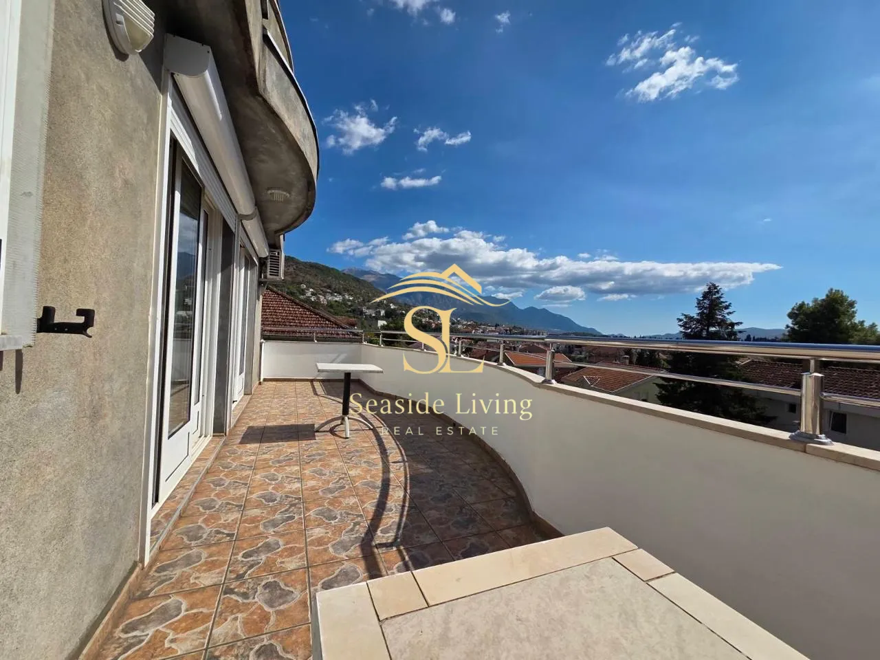 Spacious balcony with a view of the surroundings and mountains.