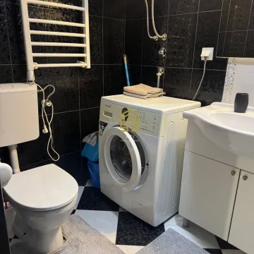 Smaller bathroom with a washing machine, sink, and toilet. - image 5