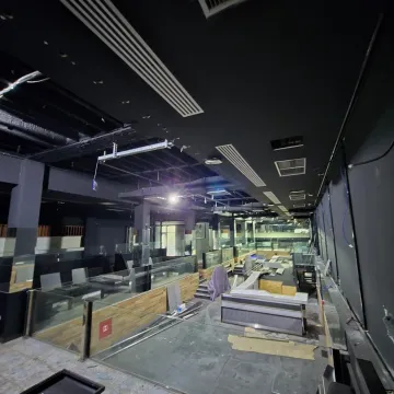 View of a larger commercial space undergoing renovation with a black ceiling. - image 2