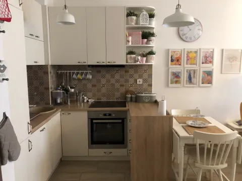 Kitchen with white cabinetry, built-in oven, and a dining table to the side. - image 10