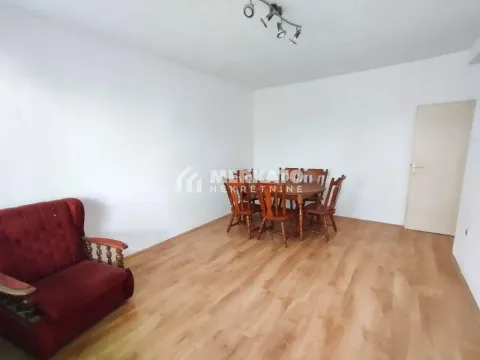 Dnevna soba sa trpezarijskim stolom i crvenom foteljom. - image 13