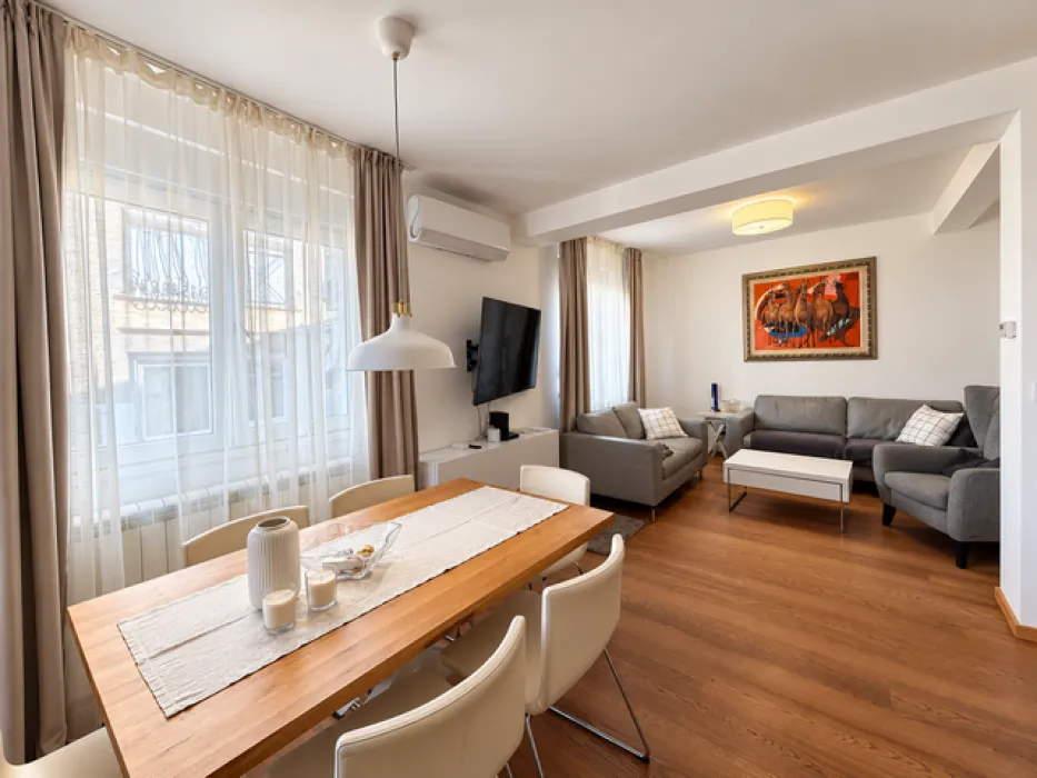 Living room with a dining area, wooden table, and seating furniture.