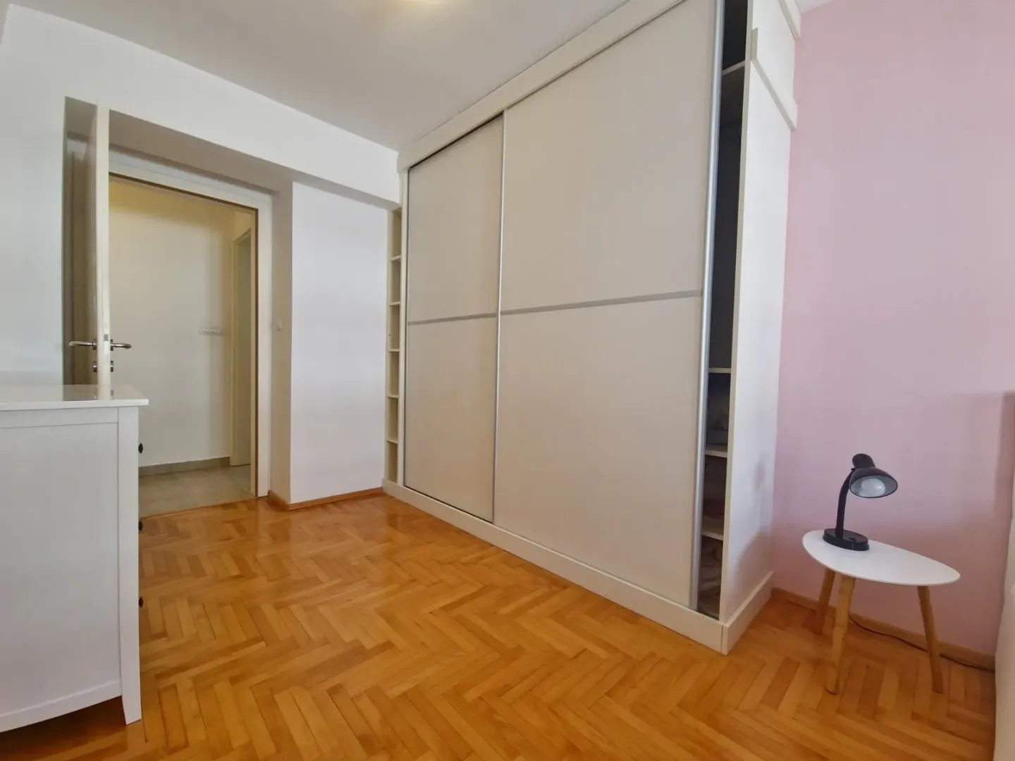 Bedroom with a large built-in wardrobe and hardwood flooring.