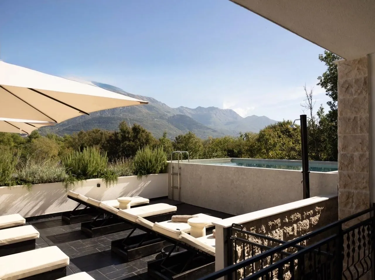 Terrace with a pool and sun loungers and a mountain view.