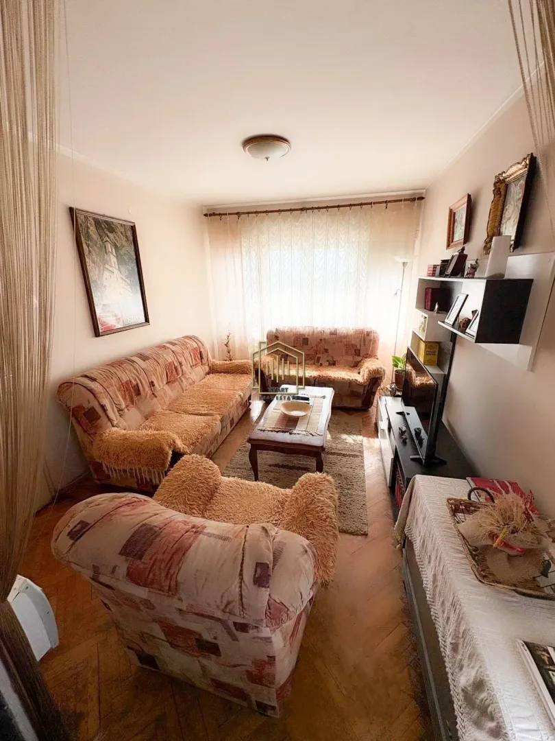 Dnevna soba sa garniturom za sjedenje, klub stolićem i televizorom.