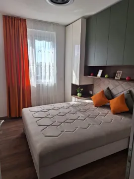 Moderna spavaća soba sa bračnim krevetom, garderoberom i narandžastim detaljima. - image 3