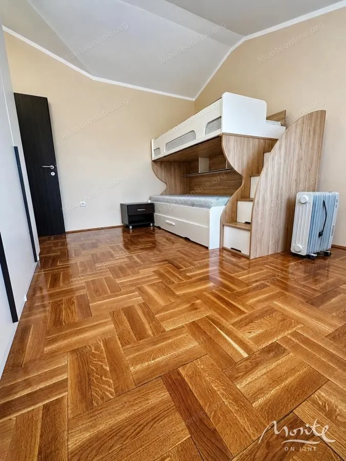 Children's bedroom with a bunk bed and parquet flooring.