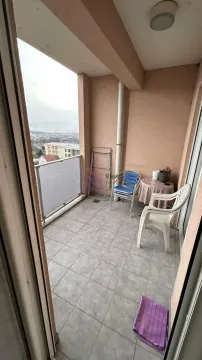 Natkriveni balkon sa pločicama, stolom, stolicama i pogledom na okolinu. - image 7