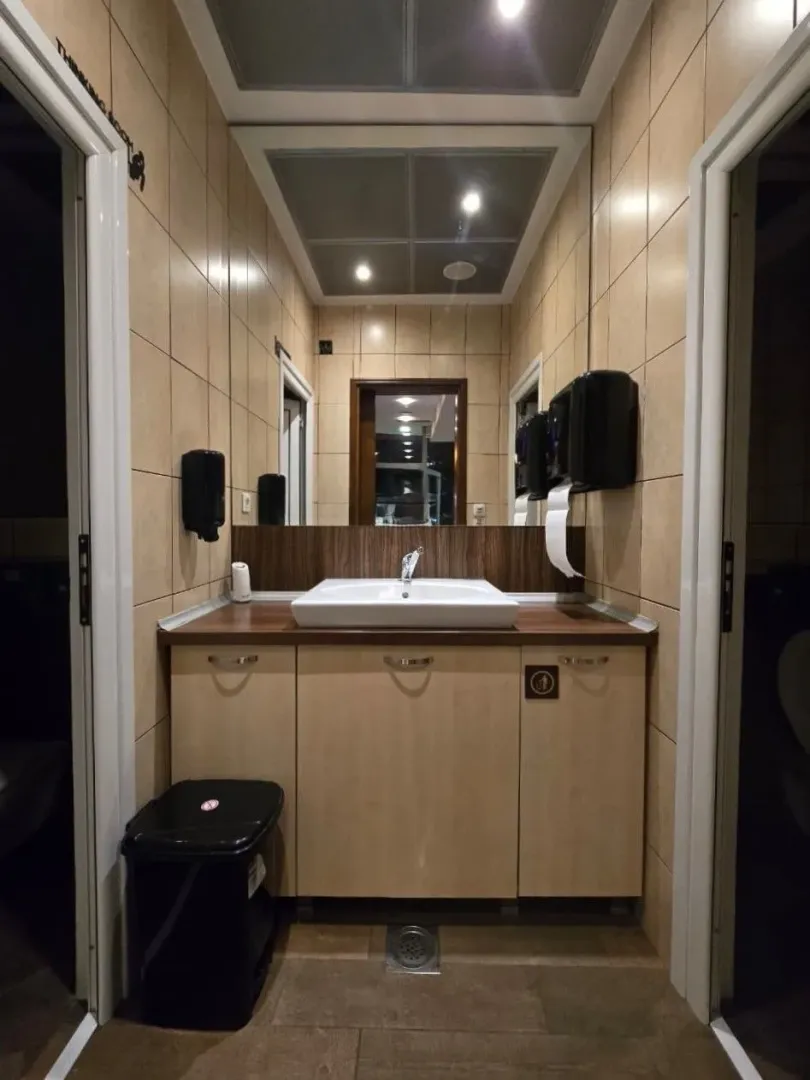 A clean bathroom featuring a sink, a large mirror, and tiled walls.