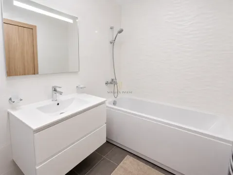 Modern white bathroom with a bathtub, washbasin, and large mirror. - image 9