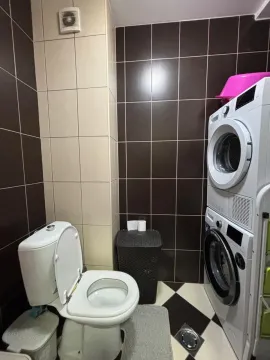 Kupatilo sa wc šoljom i mašinama za pranje i sušenje veša. - image 15