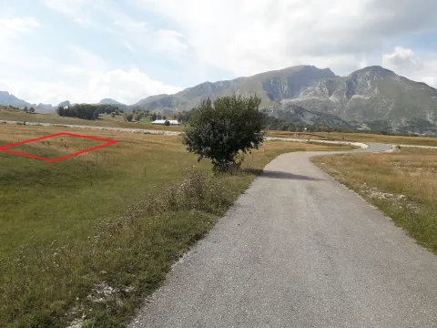 Pogled na plac sa označenom granicom i planinskim pejzažom u pozadini. - image 7
