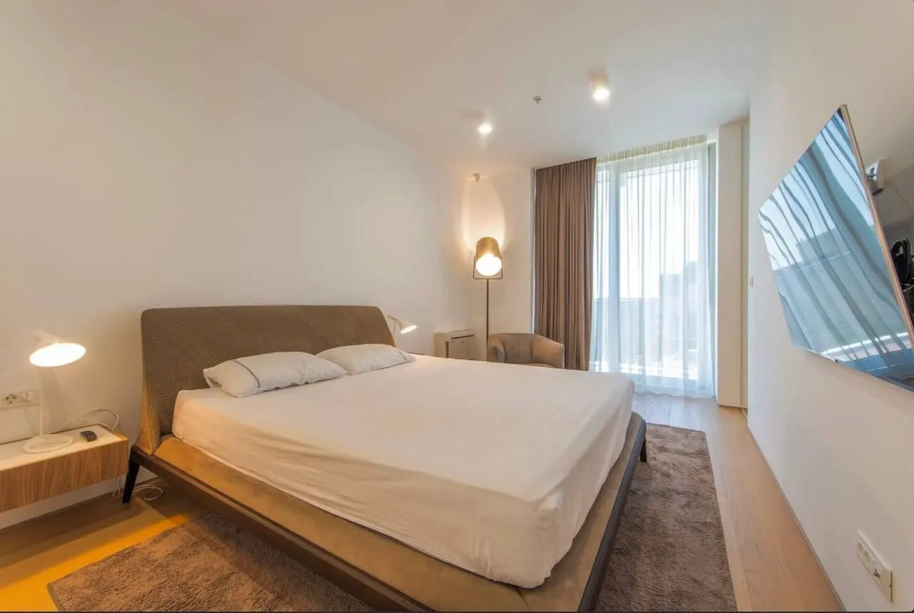 Modern bedroom with a double bed, TV, and access to the terrace.