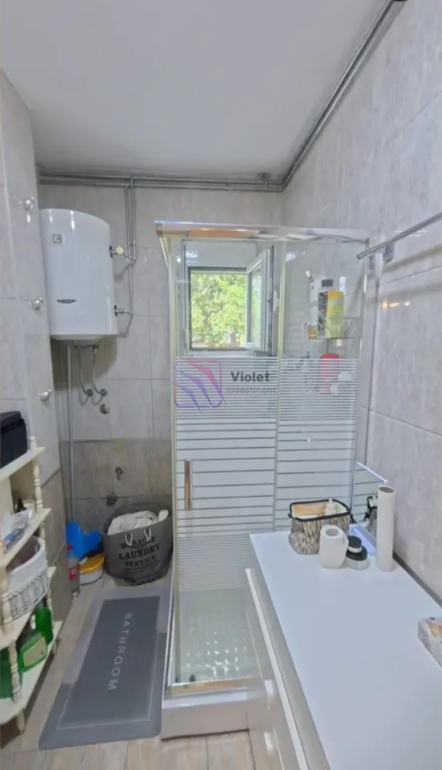 Bathroom equipped with a shower cabin, washbasin, and water heater.