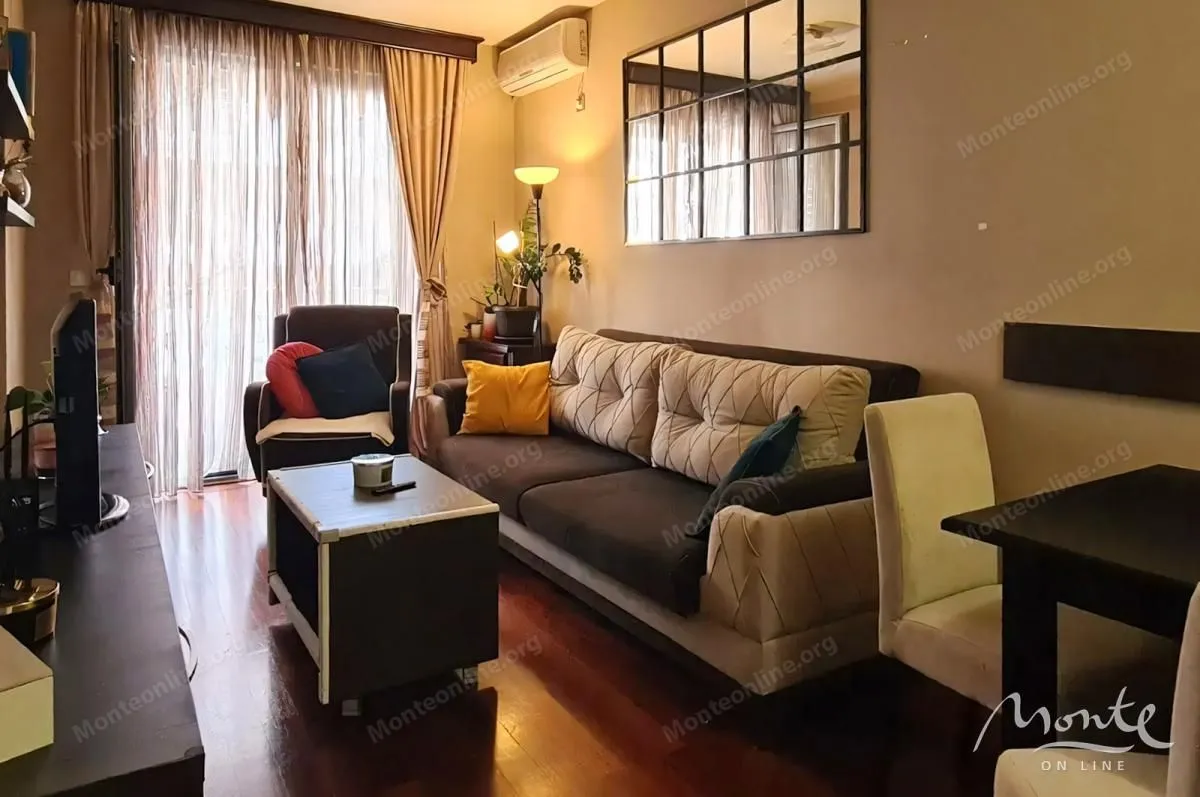 Living room with a sofa, coffee table and TV.