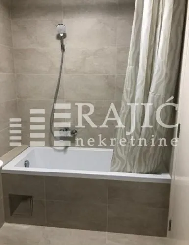 View of the bathroom with a bathtub and shower.