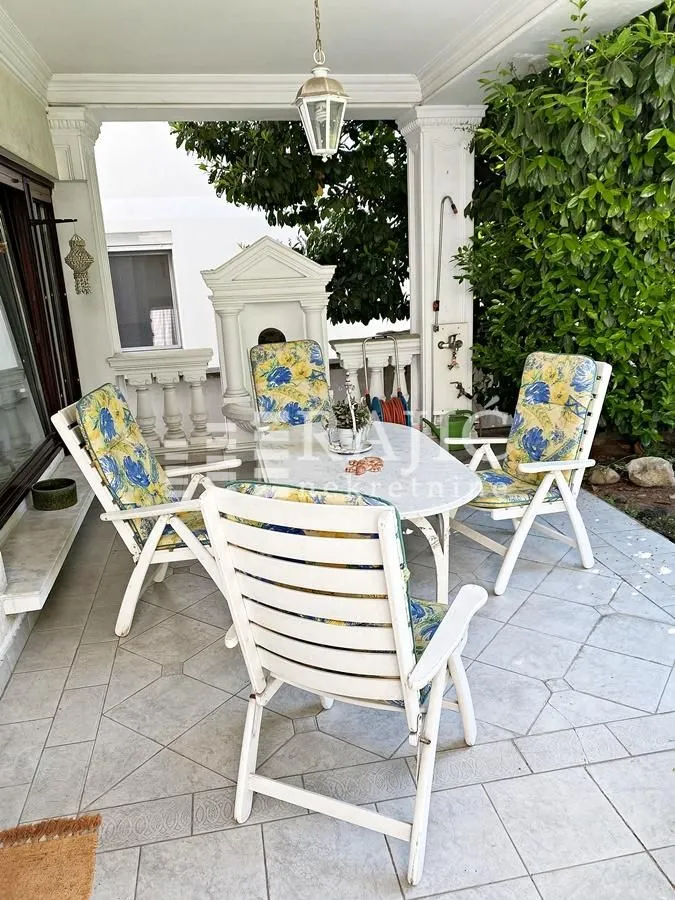 Covered terrace with seating furniture.