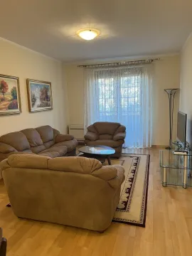 Bright living room featuring comfortable sofas, a rug, and a TV. - image 4