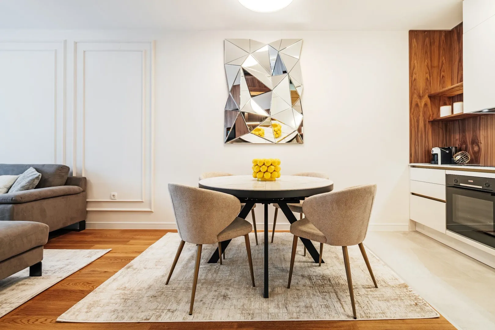Modern living room with a dining table and a kitchen in the background.