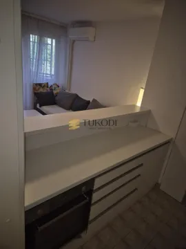 Manja kuhinja sa ugrađenom rernom i šankom povezana sa dnevnim boravkom. - image 5